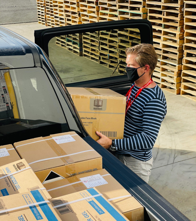 Ein Mann mit Mundschutz räumt einen Umzugswagen ein